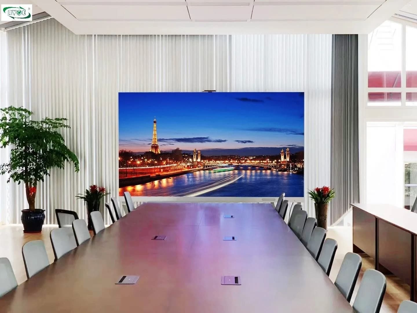 LED screen in a boardroom with a long table and a potted plant