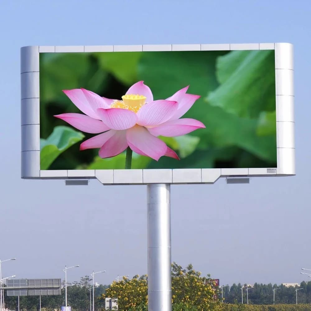 Pole-mounted LED screen showing a lotus flower beside a road