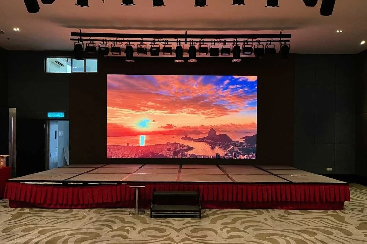 Indoor LED wall on a stage with a red skirt and lighting truss